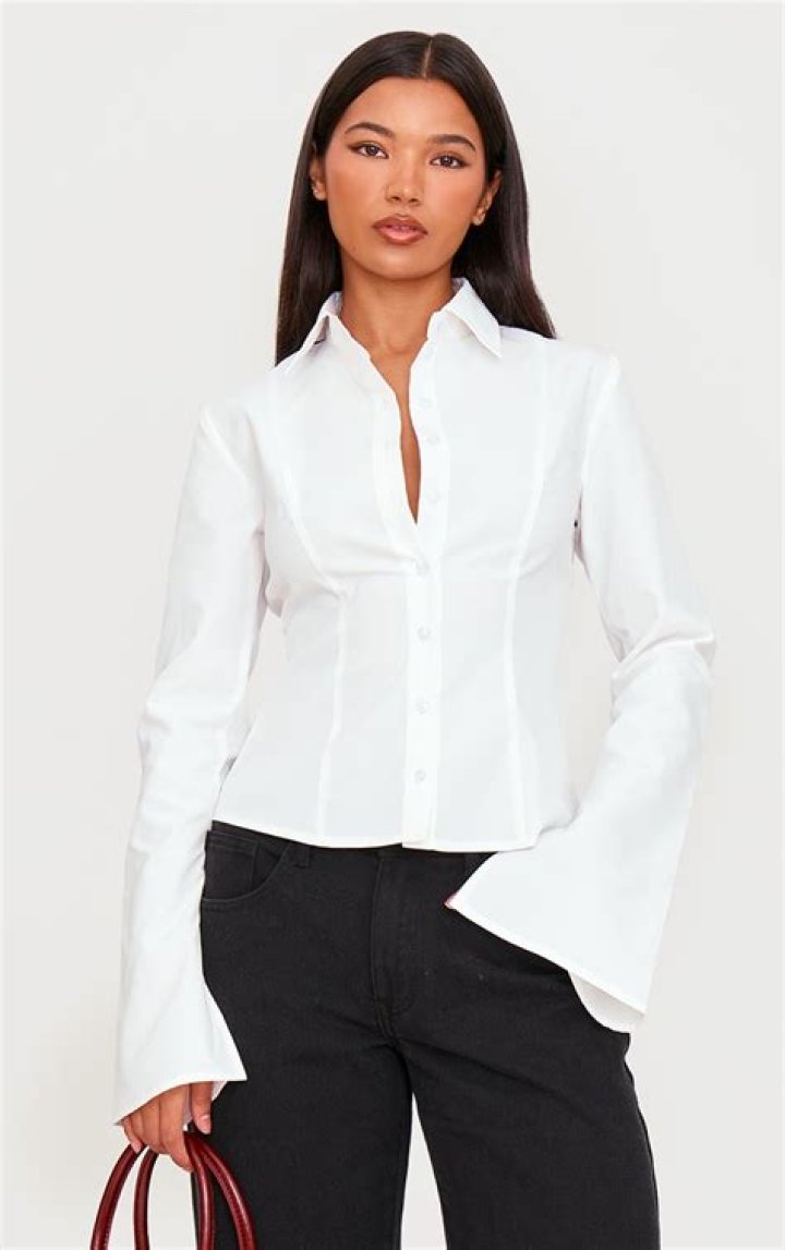 Petite woman wearing fitted white linen shirt and high waisted black trousers