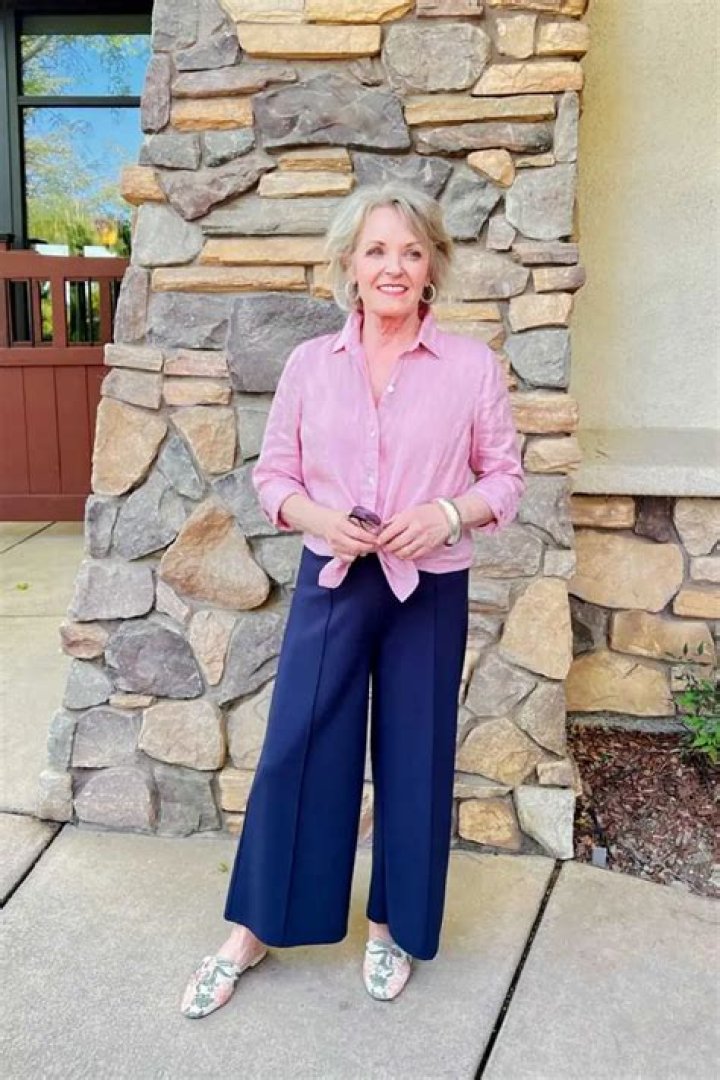 Woman in wide leg pants bending over plants